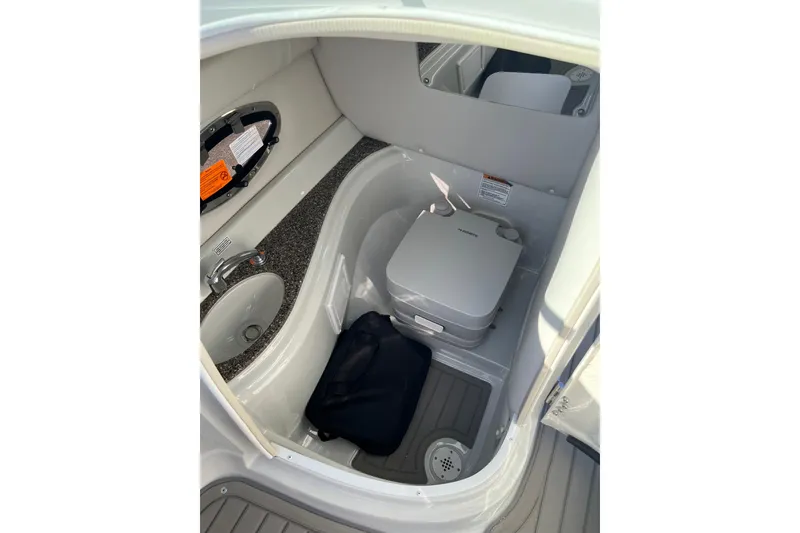 Slide: The Image of 2026 Crownline Eclipse E235 boat interior with sink and portable toilet. - 17