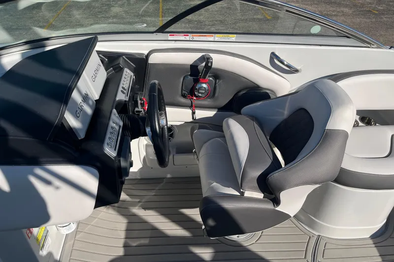 Slide: The Image of 2026 Crownline Eclipse E235 boat cockpit with Garmin displays and comfortable seating. - 18
