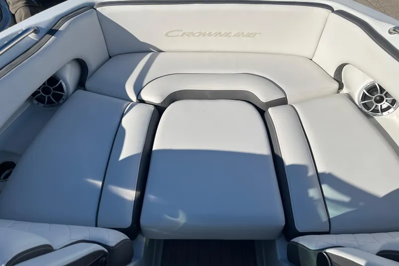 Slide: The Image of 2026 Crownline Eclipse E235 boat interior with cushioned seating and built-in speakers. - 9