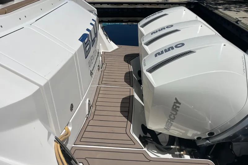 Slide: The Image of 2020 Sea Ray Sundancer 320 Outboard with triple Mercury engines on a wooden deck. - 13