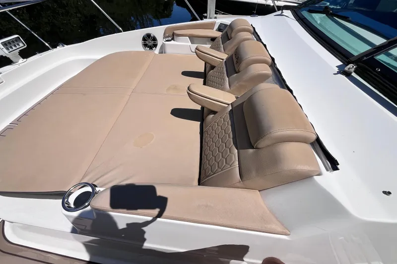 Slide: The Image of 2020 Sea Ray Sundancer 320 Outboard with extra wide lounging area for three adults with head rests and arm rests on forward deck. Sound speakers and cupholders on both sides for added comfort. - 21