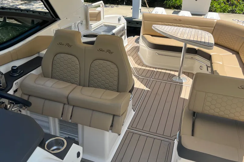 Slide: The Image of 2020 Sea Ray Sundancer 320 Outboard interior with tan seating and wooden table. - 31