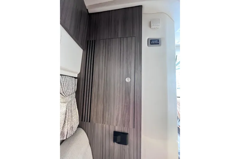 Slide: The Image of 2020 Sea Ray Sundancer 320 Outboard interior with wood paneling and control panel. - 58