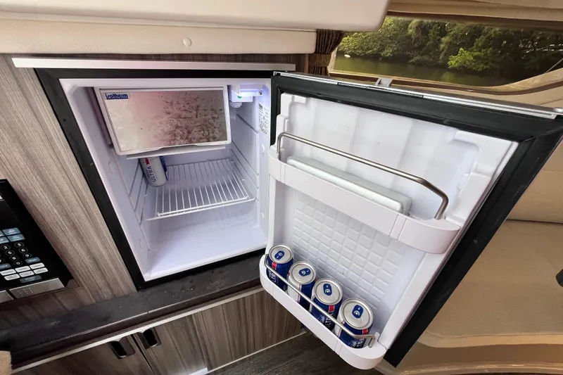 Slide: The Image of Mini fridge inside 2020 Sea Ray Sundancer 320 Outboard, stocked with beverages. - 61
