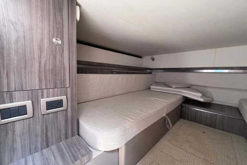 Slide: The Image of 2020 Sea Ray Sundancer 320 Outboard cabin interior with modern wood finish and seating. - 67