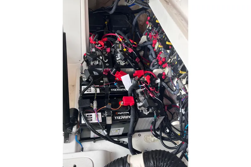 Slide: The Image of 2020 Sea Ray Sundancer 320 Outboard battery compartment with wiring and connections. - 80