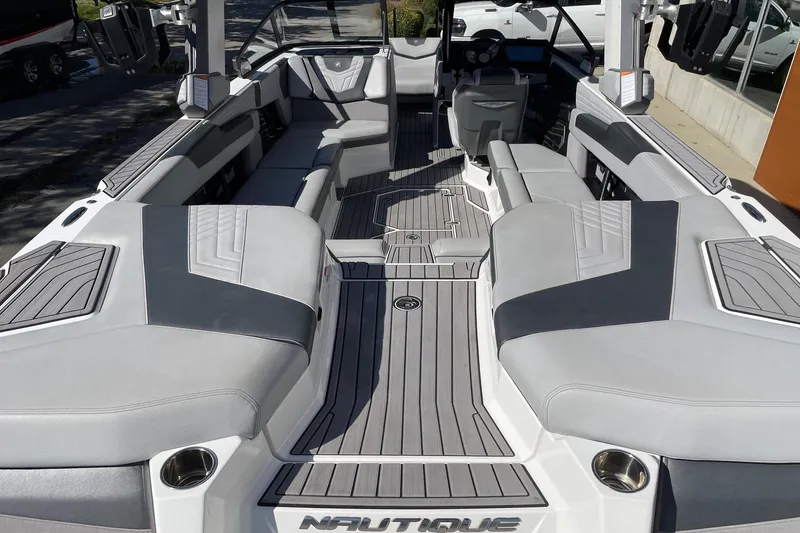 Slide: The Image of 2022 Nautique Super Air Nautique G25 boat interior with sleek gray seating and modern design. - 4