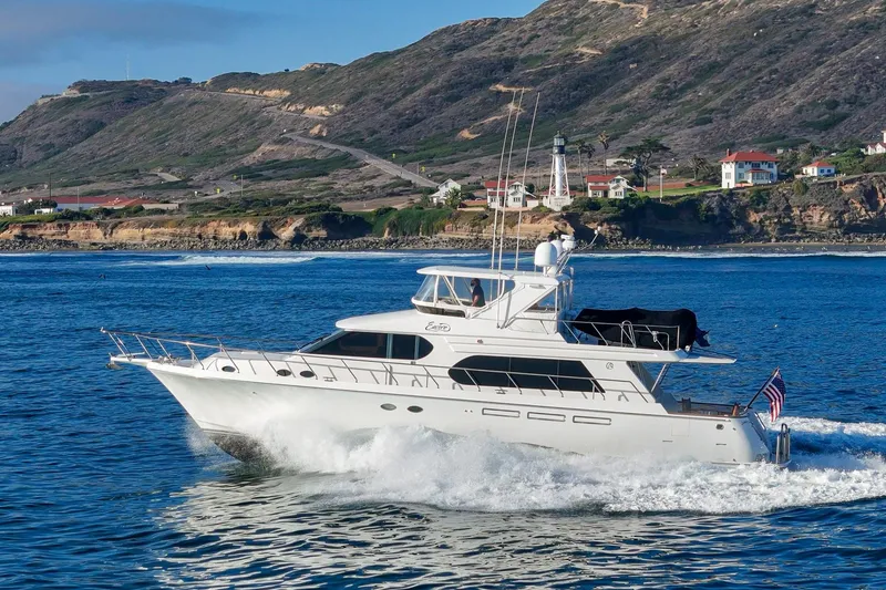 Slide: The Image of Luxury 2006 Ocean Alexander 64 Pilothouse yacht cruising near scenic coastal cliffs. - 0