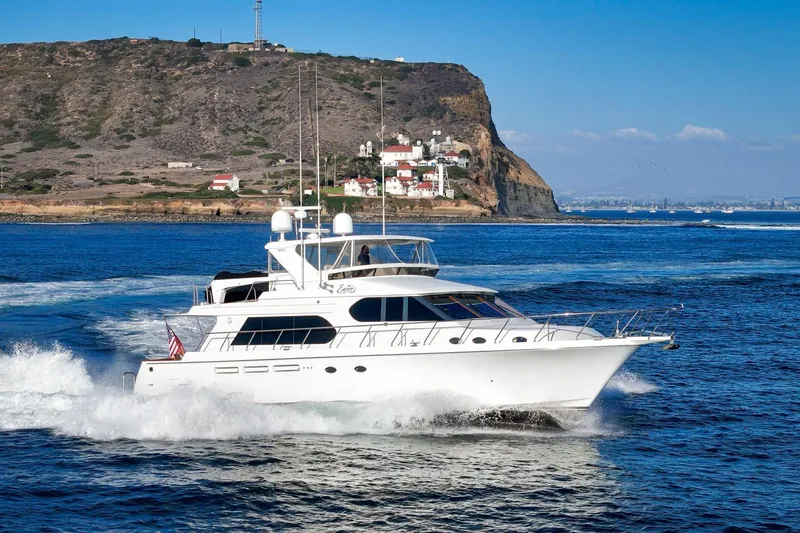 Slide: The Image of 2006 Ocean Alexander 64 Pilothouse yacht cruising near scenic coastal cliffs. - 10