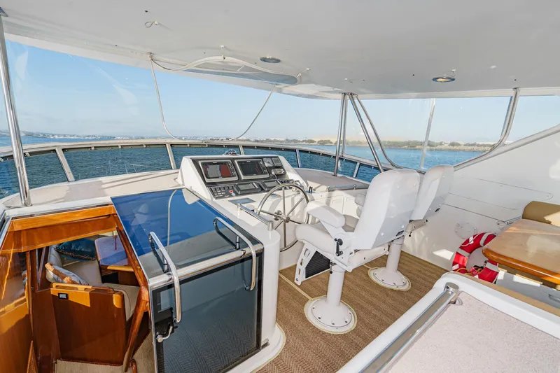 Slide: The Image of Pilothouse of 2006 Ocean Alexander 64, featuring helm chairs and navigation equipment. - 29