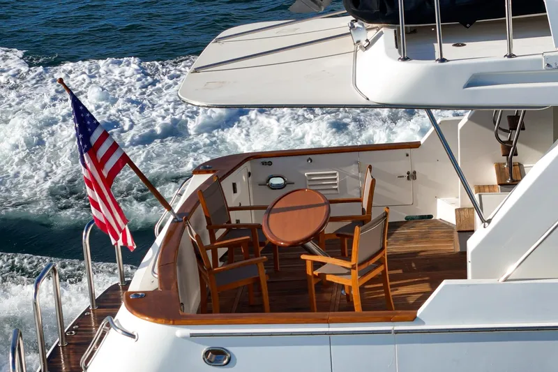 Slide: The Image of 2006 Ocean Alexander 64 Pilothouse yacht with American flag and deck seating. - 36