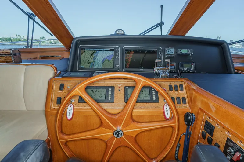 Slide: The Image of Pilothouse of 2006 Ocean Alexander 64, featuring navigation equipment and wooden steering wheel. - 49