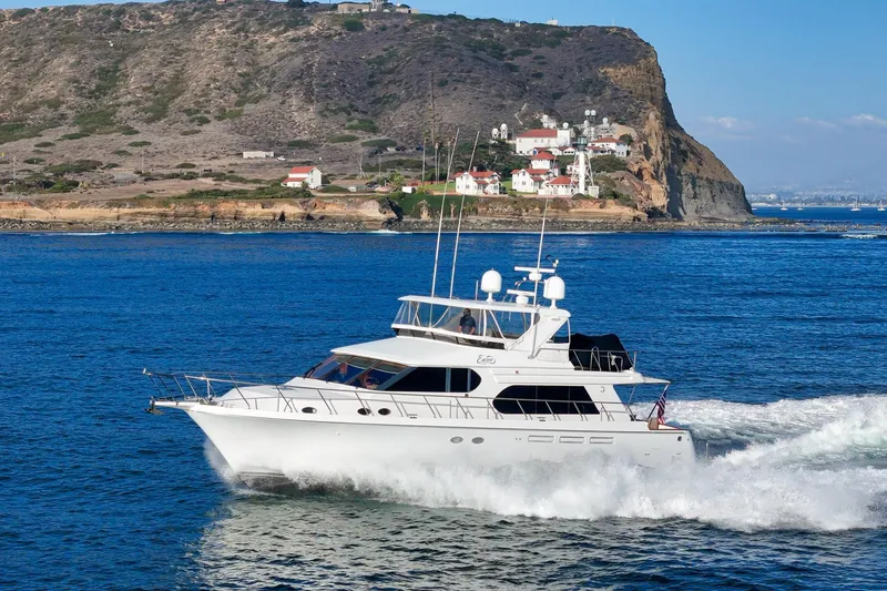 Slide: The Image of 2006 Ocean Alexander 64 Pilothouse yacht cruising near a rocky coastline. - 5