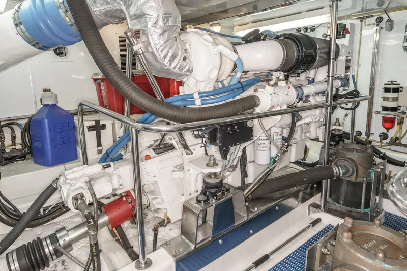 Slide: The Image of Engine room of 2006 Ocean Alexander 64 Pilothouse yacht, featuring mechanical components and used oil container. - 71