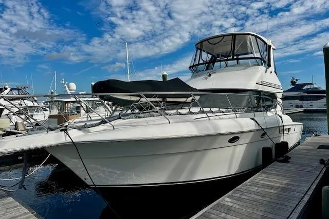 The Image of 2001 Silverton 42 Convertible yacht docked under a blue sky. - 0