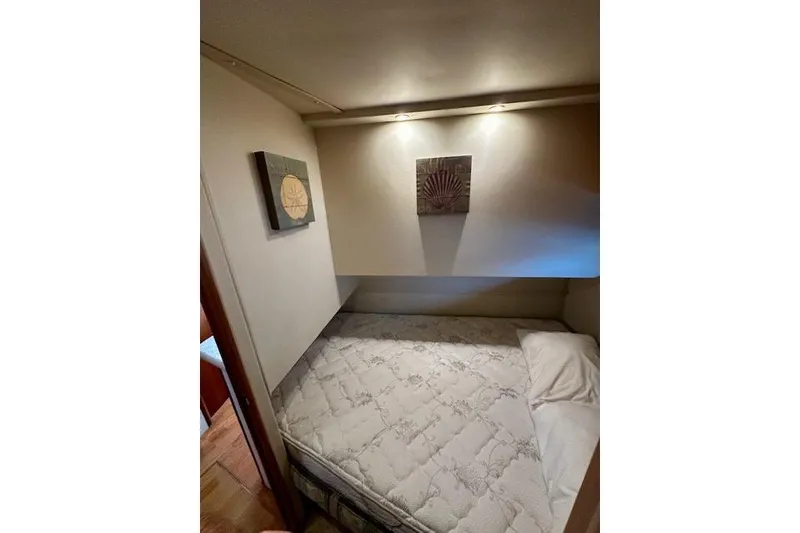 Slide: The Image of 2001 Silverton 42 Convertible cabin interior with bed and wall art. - 10