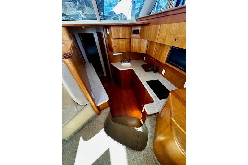 Slide: The Image of Interior of 2001 Silverton 42 Convertible yacht with modern kitchen and wood cabinetry. - 13
