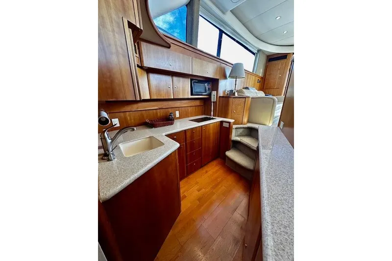 Slide: The Image of Luxurious 2001 Silverton 42 Convertible yacht interior with modern kitchen and wood cabinetry. - 15