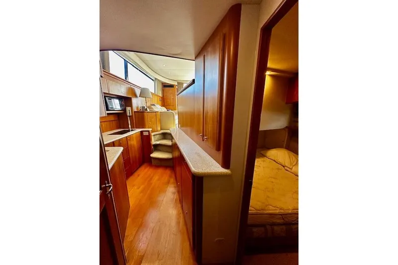 Slide: The Image of Interior of 2001 Silverton 42 Convertible yacht with wood finishes and cozy bedroom. - 16