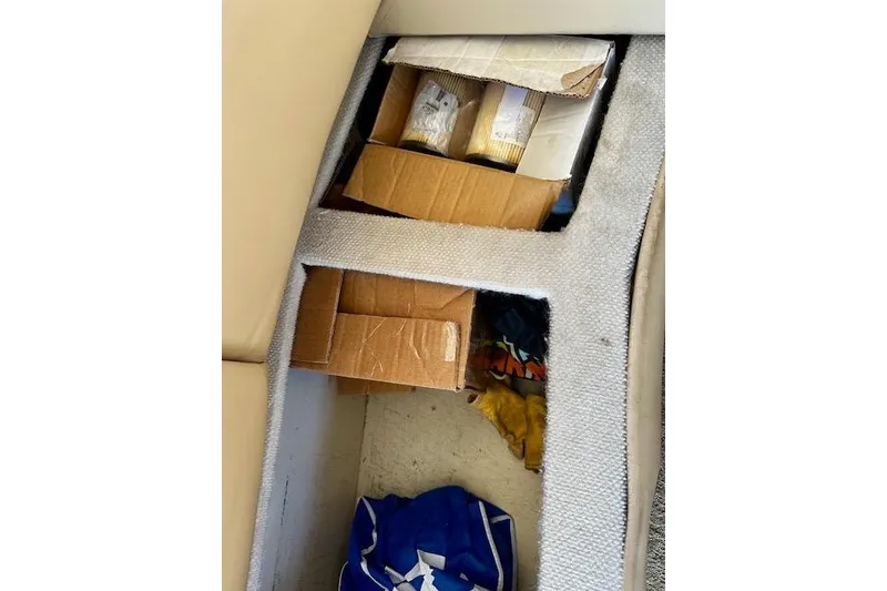 Slide: The Image of Hidden storage compartment in 2001 Silverton 42 Convertible boat with boxes and items. - 18