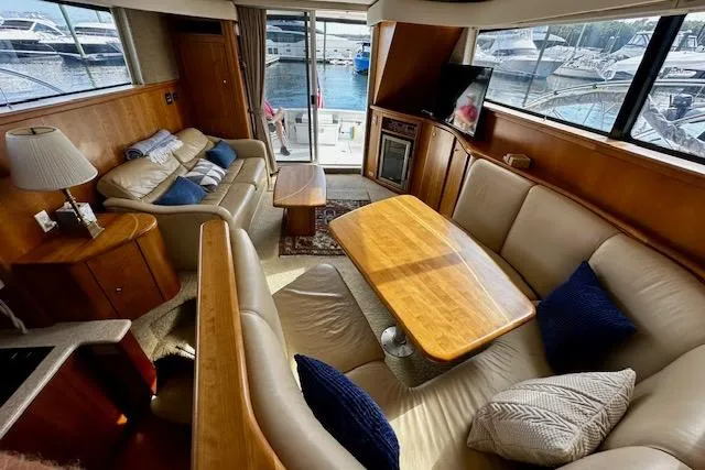 Slide: The Image of Interior of a 2001 Silverton 42 Convertible yacht with plush seating and wooden accents. - 2