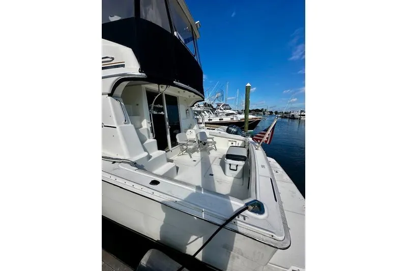 Slide: The Image of 2001 Silverton 42 Convertible yacht docked at marina under clear blue sky. - 23