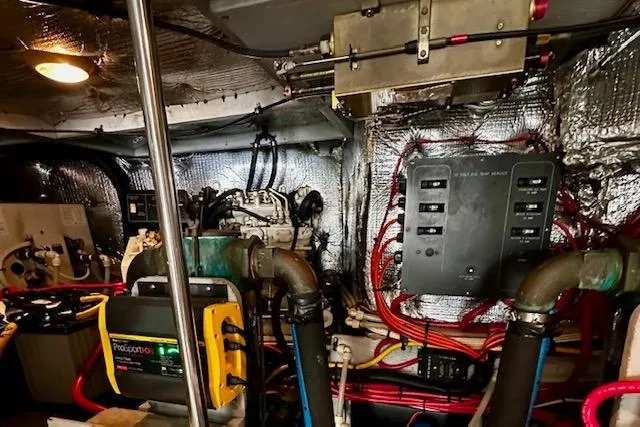 Slide: The Image of Engine room of a 2001 Silverton 42 Convertible boat, featuring wiring and machinery. - 43