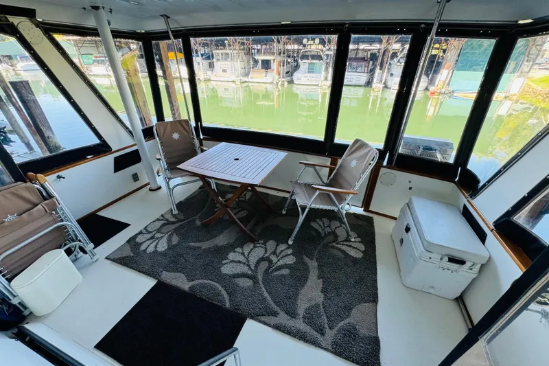 Slide: The Image of 1988 Sea Ray 415 Aft Cabin interior with chairs, table, and marina view. - 14