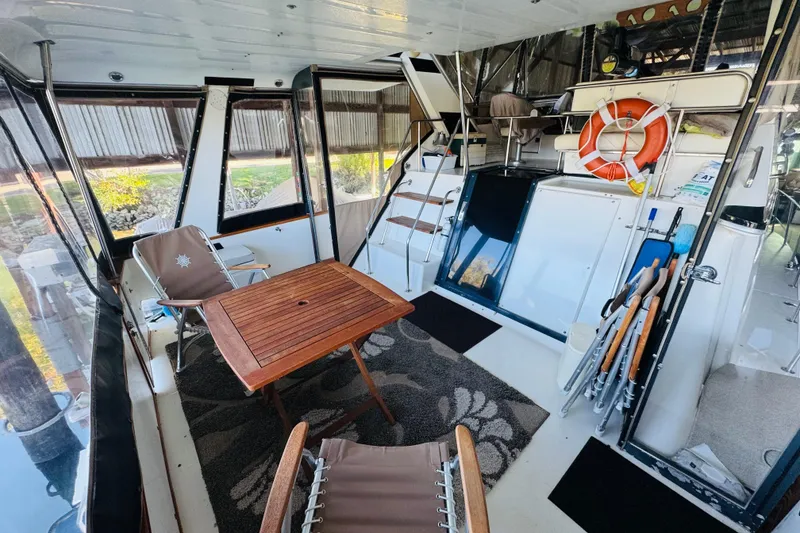 Slide: The Image of 1988 Sea Ray 415 Aft Cabin interior with seating, table, and life preserver. - 15