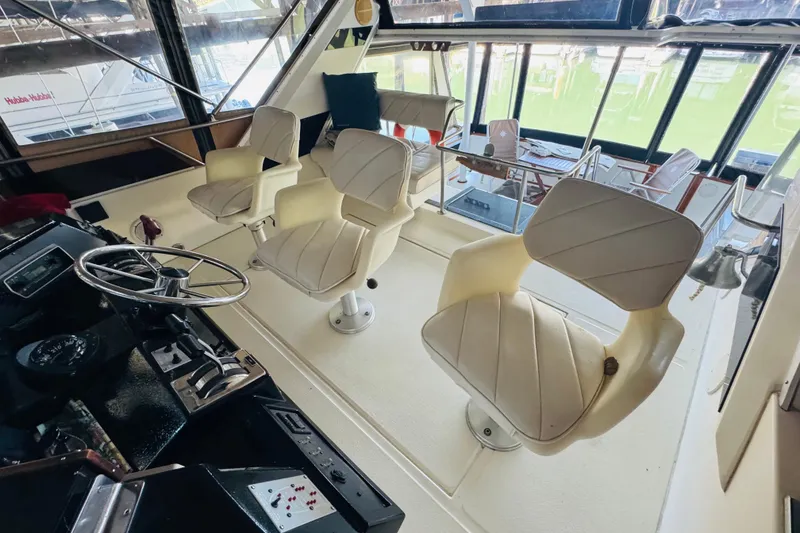 Slide: The Image of 1988 Sea Ray 415 Aft Cabin interior with helm and swivel chairs. - 17
