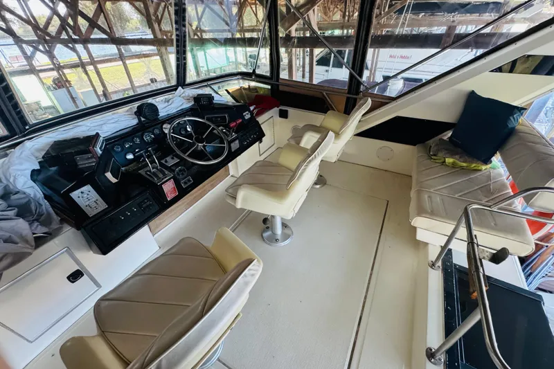 Slide: The Image of 1988 Sea Ray 415 Aft Cabin helm with beige seating and steering wheel. - 18