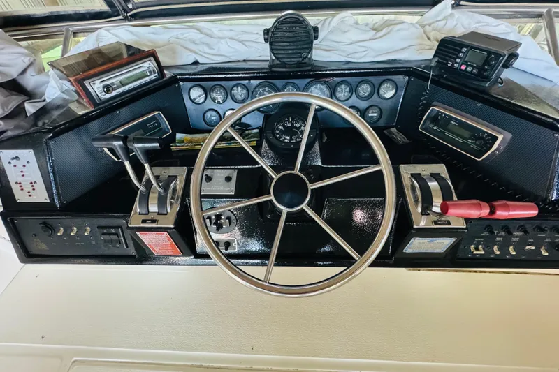 Slide: The Image of 1988 Sea Ray 415 Aft Cabin helm with steering wheel and control panel. - 20