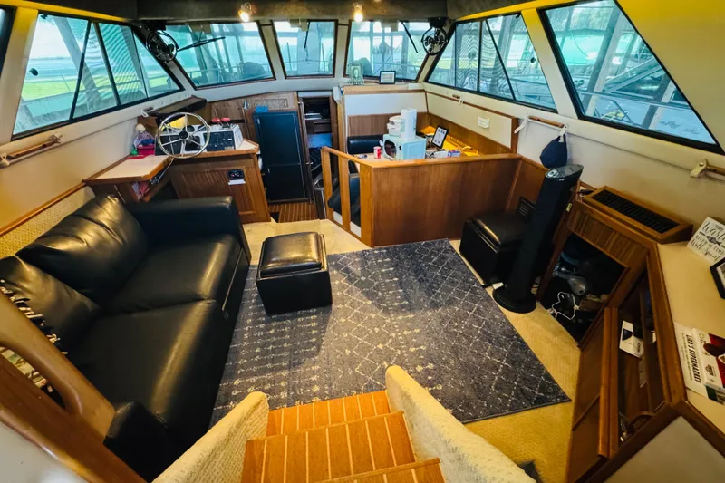 Slide: The Image of 1988 Sea Ray 415 Aft Cabin interior with leather sofa, helm, and nautical decor. - 21