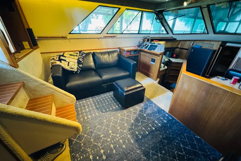 Slide: The Image of 1988 Sea Ray 415 Aft Cabin interior with black leather sofa, carpet, and wooden cabinetry. - 22