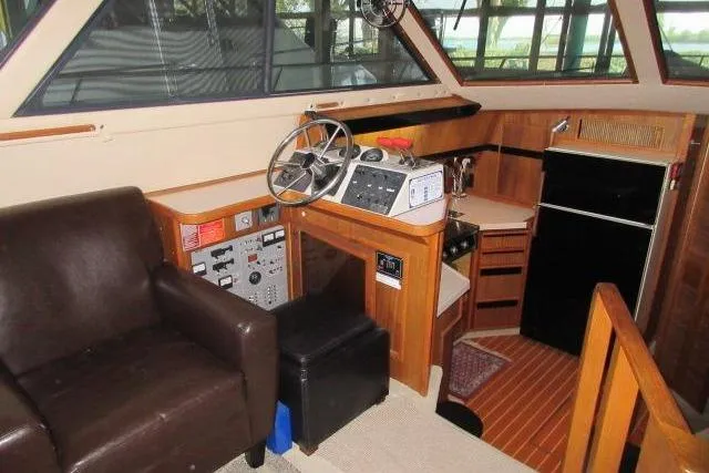 Slide: The Image of 1988 Sea Ray 415 Aft Cabin interior with helm, seating, and kitchenette. - 25