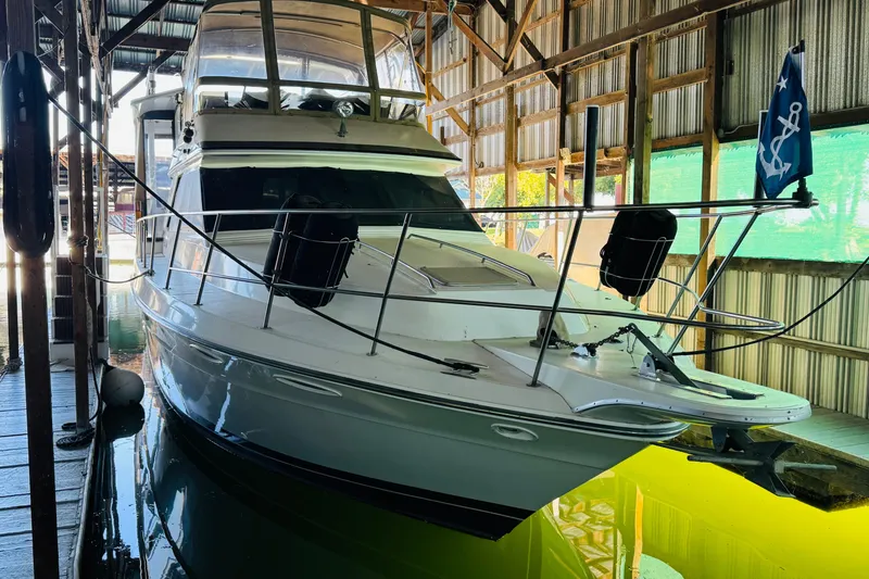 Slide: The Image of 1988 Sea Ray 415 Aft Cabin yacht docked in a covered marina. - 3