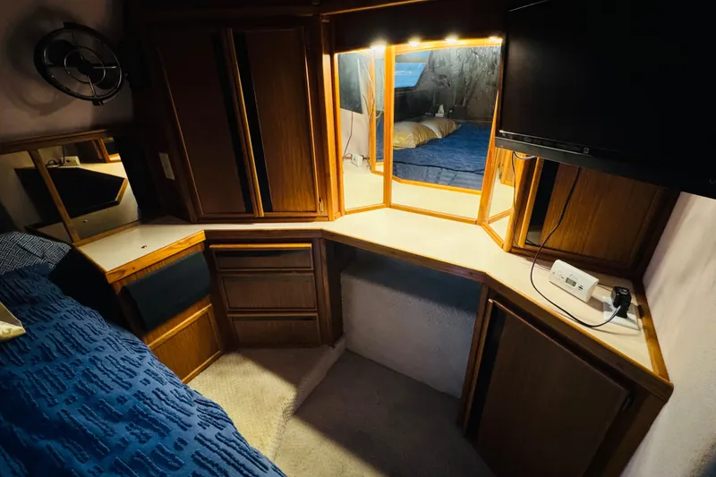 Slide: The Image of 1988 Sea Ray 415 Aft Cabin interior with wood cabinetry and vanity mirror. - 33
