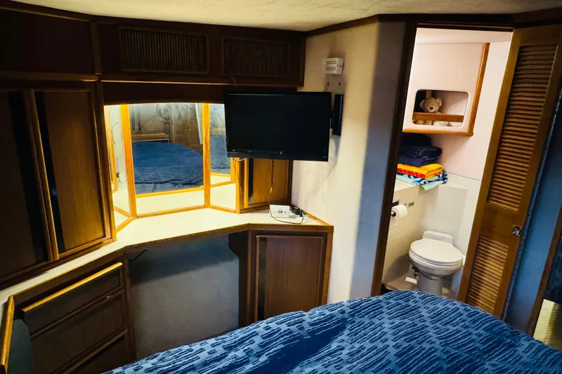 Slide: The Image of 1988 Sea Ray 415 Aft Cabin interior with cozy bedroom and bathroom view. - 34