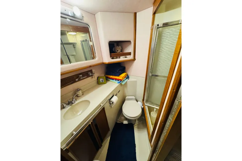 Slide: The Image of 1988 Sea Ray 415 Aft Cabin bathroom with sink, toilet, and shower. - 36
