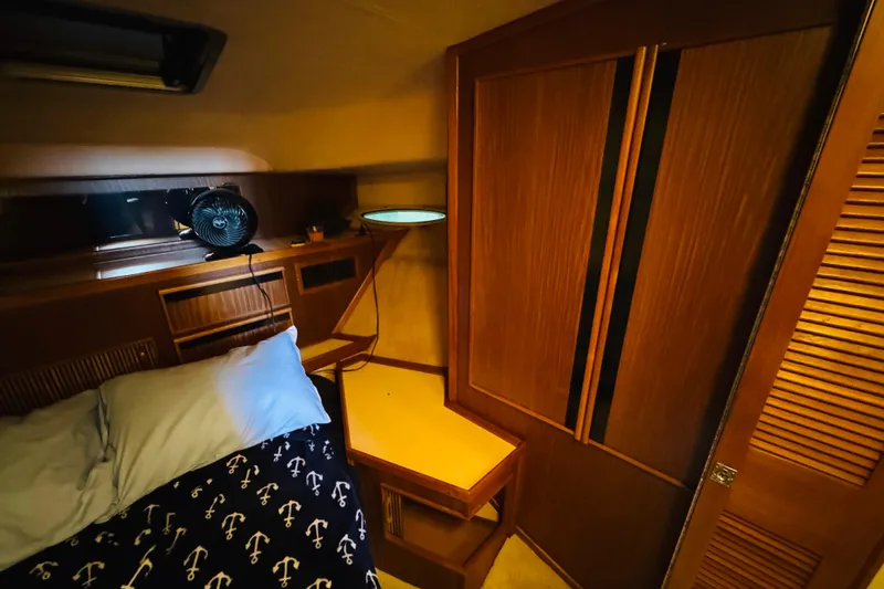 Slide: The Image of 1988 Sea Ray 415 Aft Cabin interior with bed, fan, and wooden cabinetry. - 39
