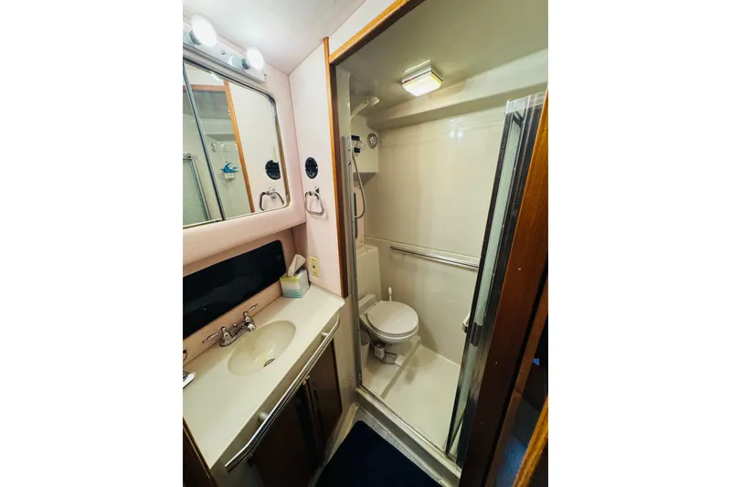 Slide: The Image of 1988 Sea Ray 415 Aft Cabin bathroom with sink, mirror, and shower. - 40