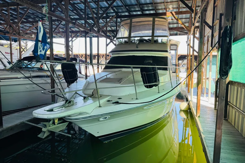 Slide: The Image of 1988 Sea Ray 415 Aft Cabin yacht docked in a covered marina. - 5