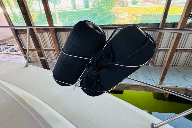 Slide: The Image of 1988 Sea Ray 415 Aft Cabin boat with black fenders secured on railing. - 7