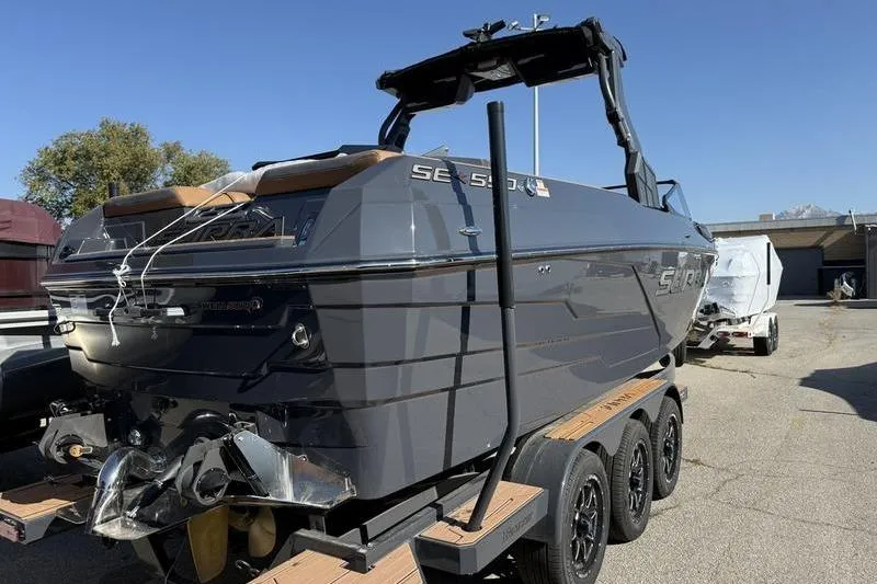 Slide: The Image of 2025 Supra SE 575 boat on trailer, sleek design, parked outdoors. - 4