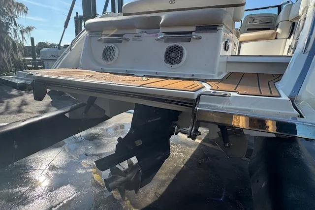 Slide: The Image of 2015 Cobalt 26SD boat stern with teak swim platform and outboard motor. - 11