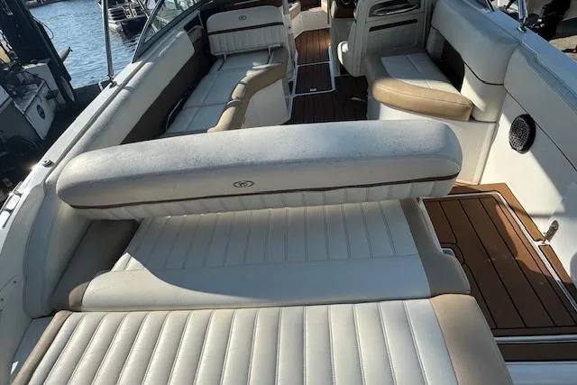 Slide: The Image of 2015 Cobalt 26SD boat interior with white and tan seating, wooden flooring, and spacious layout. - 13