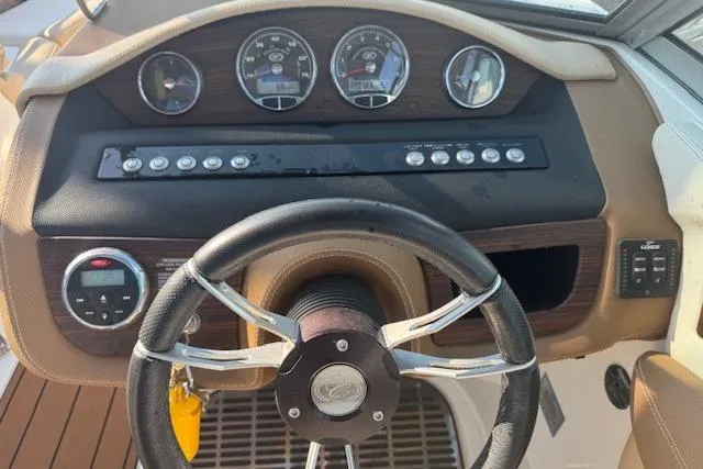 Slide: The Image of Steering wheel and dashboard of a 2015 Cobalt 26SD boat with gauges and controls. - 25