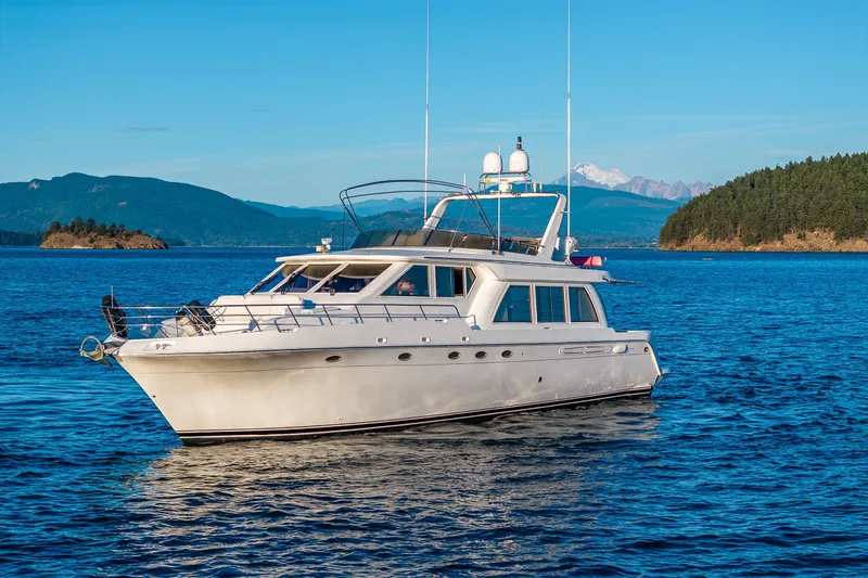 Slide: The Image of 2001 Navigator 61' Pilothouse yacht cruising on scenic blue waters with mountainous backdrop. - 23