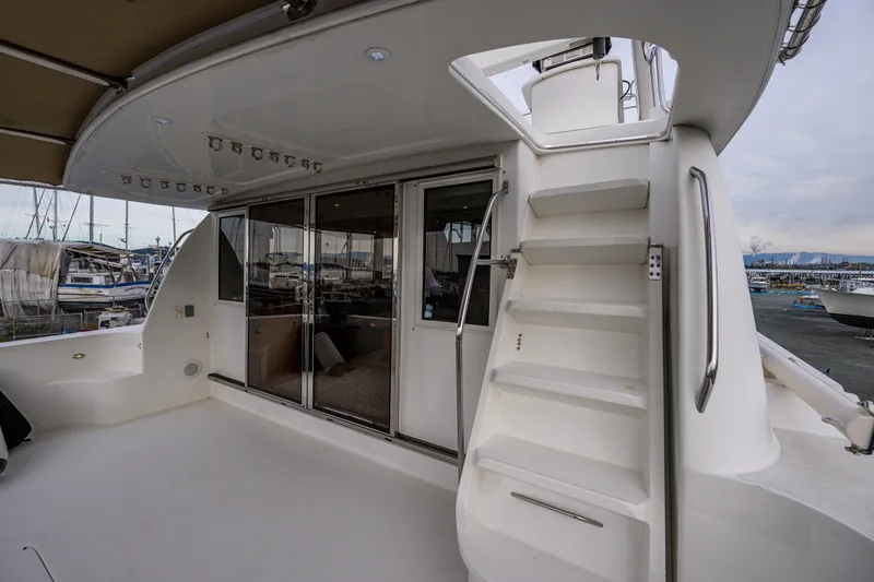 Slide: The Image of 2001 Navigator 61' Pilothouse yacht deck with stairs and sliding glass doors. - 69