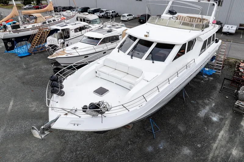 Slide: The Image of 2001 Navigator 61' Pilothouse yacht on dry dock, surrounded by other boats. - 48